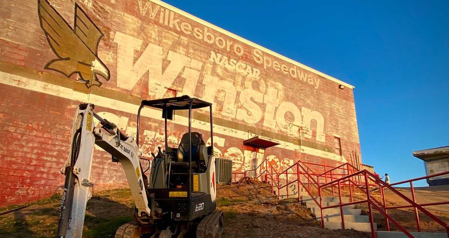 Construction equipment sits in front of the Winston sign at the entrance of North Wilkesboro Speedway