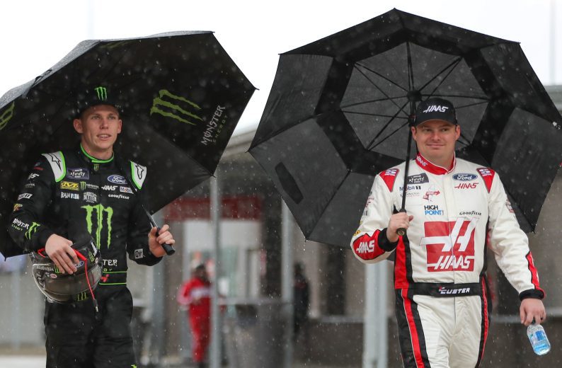 Riley Herbst and Cole Custer walk pit road at Richmond under umbrellas
