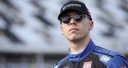 Dean Thompson looks on in sunglasses.