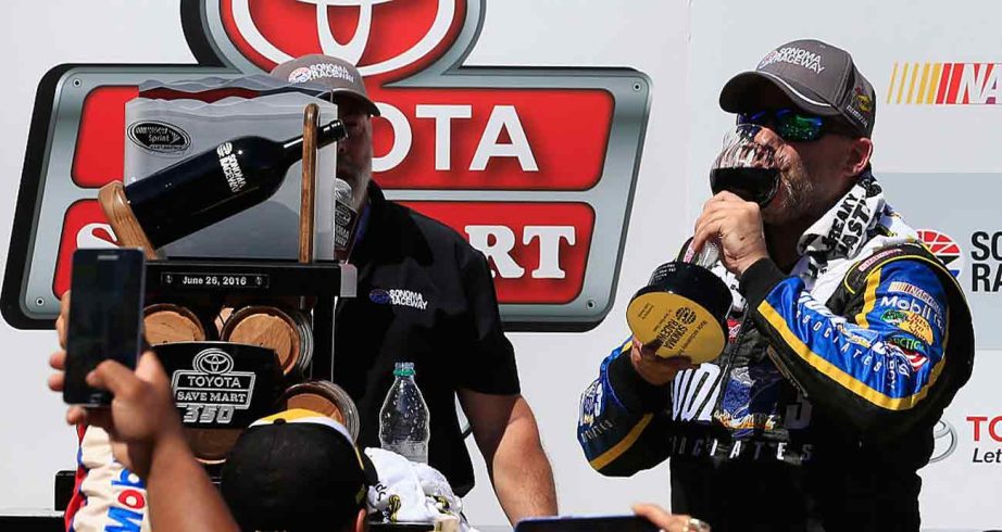 Tony Stewart celebrates win at Sonoma Raceway with sip of wine.