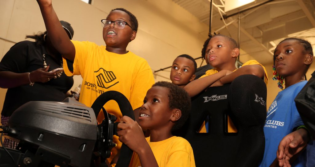 Members of the Boys and Girls Clubs of America play on a simulator