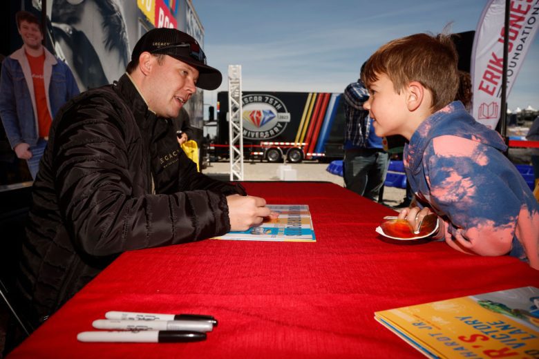 Erik Jones signs a book for a young fan