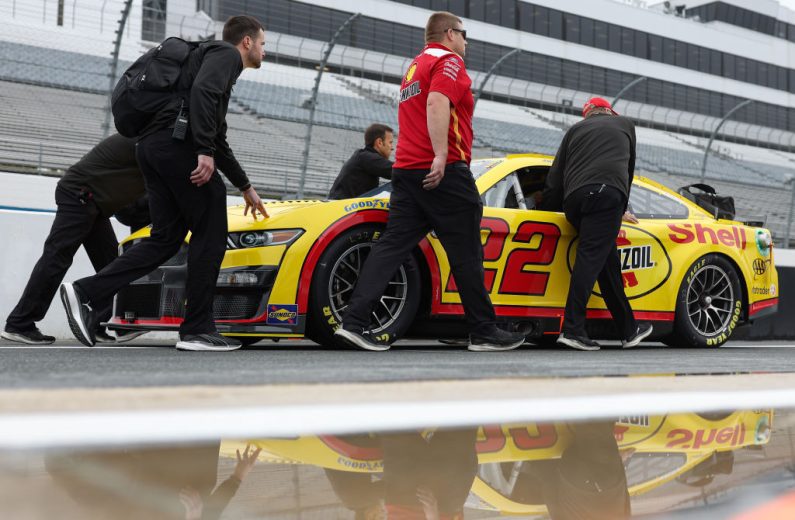 Joey Logano's car pushed on pit road