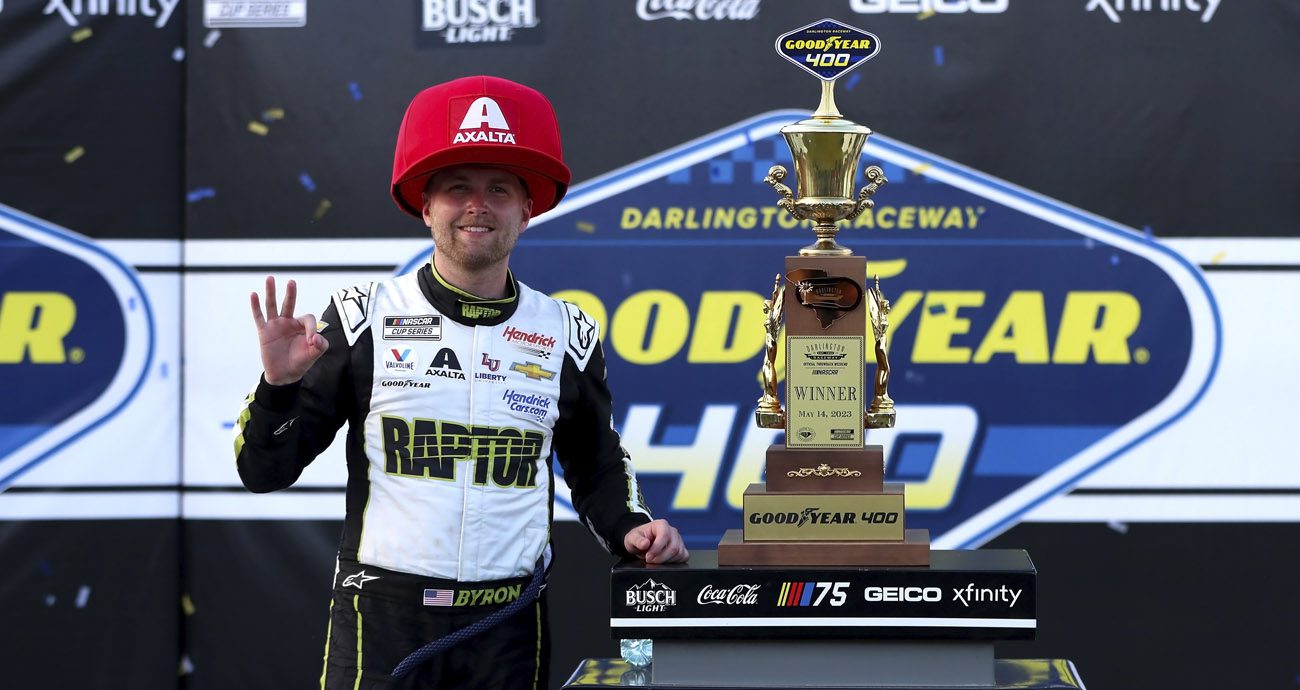 William Byron poses for photos in Victory Lane wearing a Big Hat.