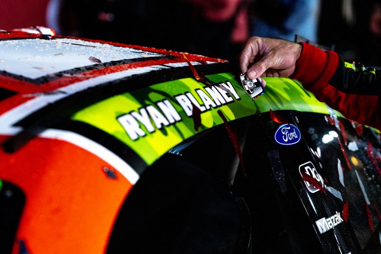 Ryan Blaney places a win sticker on his No. 12 car after winning the Coca-Cola 600