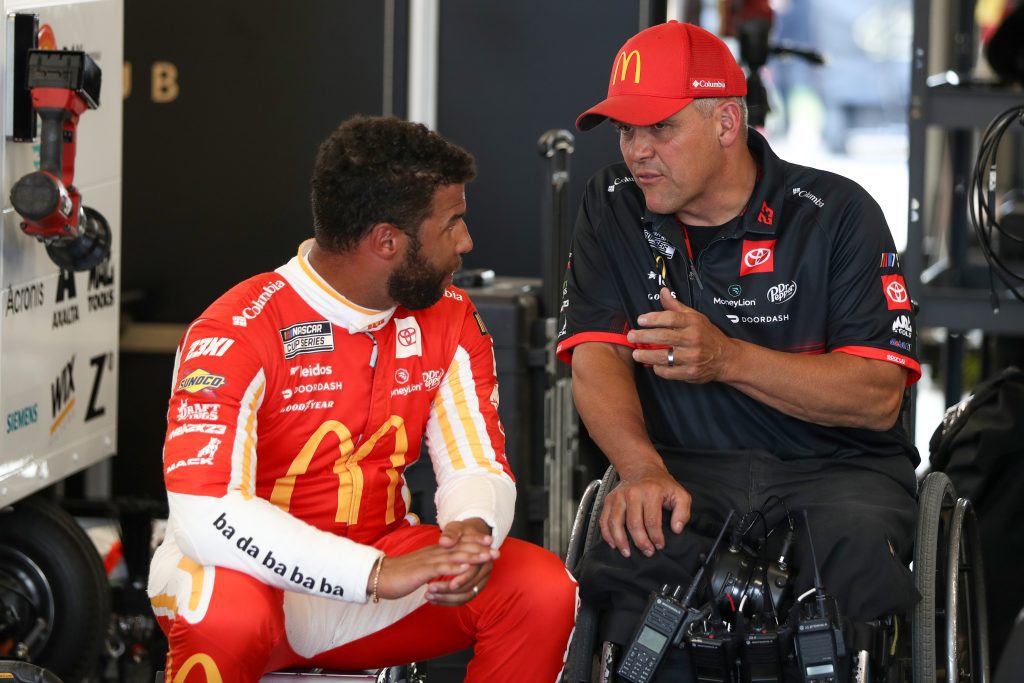 Bubba Wallace, left, and crew chief Bootie Barker talk in the NASCAR garage