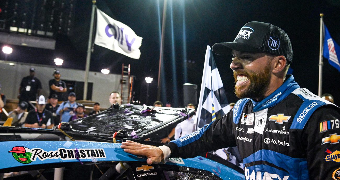 Ross Chastain places winner sticker on car.