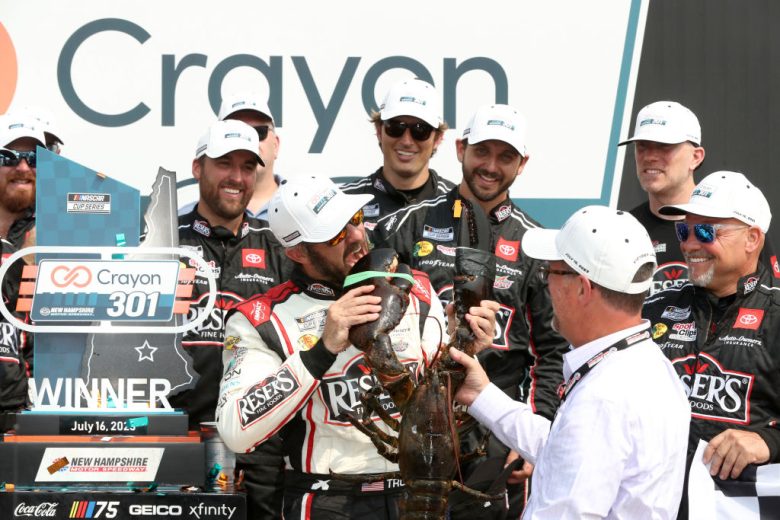 Martin Truex Jr. bits a lobster claw following his win at New Hampshire Motor Speedway.