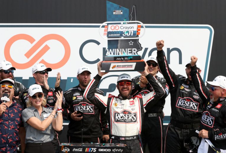 Martin Truex Jr. hoist trophy at New Hampshire Motor Speedway.