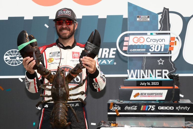 LOUDON, NEW HAMPSHIRE - JULY 17: Martin Truex Jr., driver of the #19 Reser's Fine Foods Toyota, poses with Loudon the Lobster in victory lane after winning the NASCAR Cup Series Crayon 301 at New Hampshire Motor Speedway on July 17, 2023 in Loudon, New Hampshire. (Photo by Meg Oliphant/Getty Images)