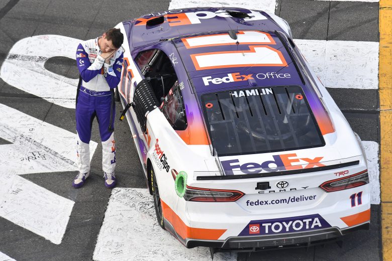 Denny Hamlin pretends to put himself to sleep while celebrating following his Pocono win