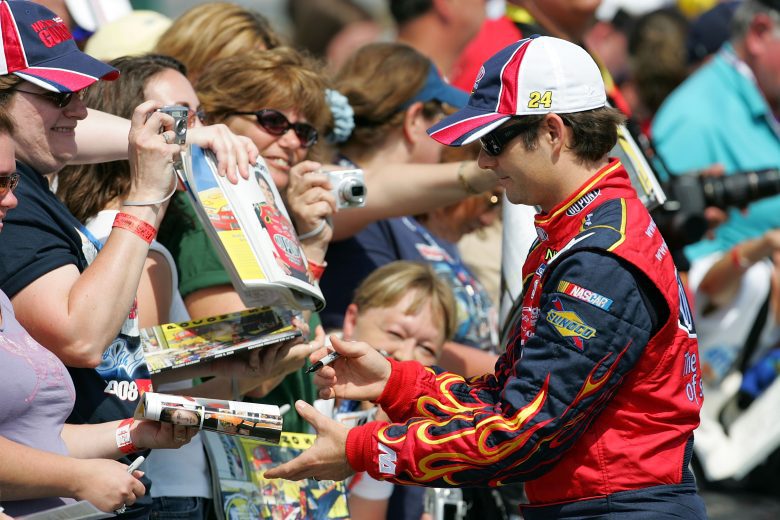 Jeff Gordon, in his 2008 fire suit, signs autographs for fans