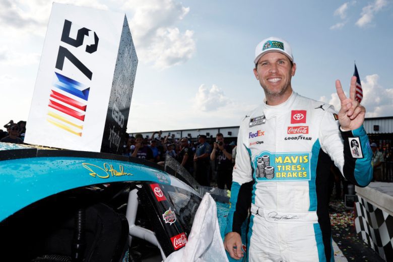 Denny Hamlin poses for a photo next to his winner sticker at Pocono Raceway.