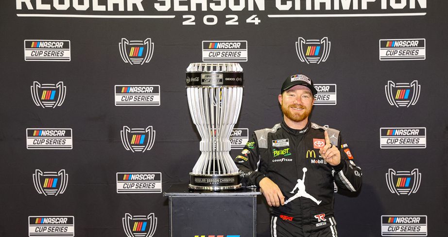 Tyler Reddick stands next to Regular Season trophy.