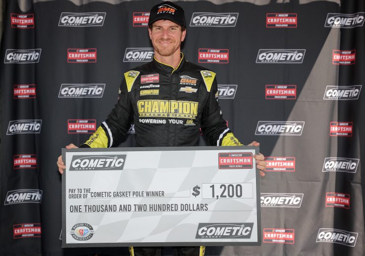 Grant Enfinger poses with a check after winning the pole in Milwaukee