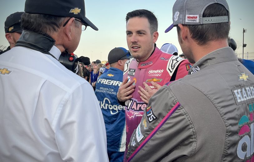 Alex Bowman looks on.