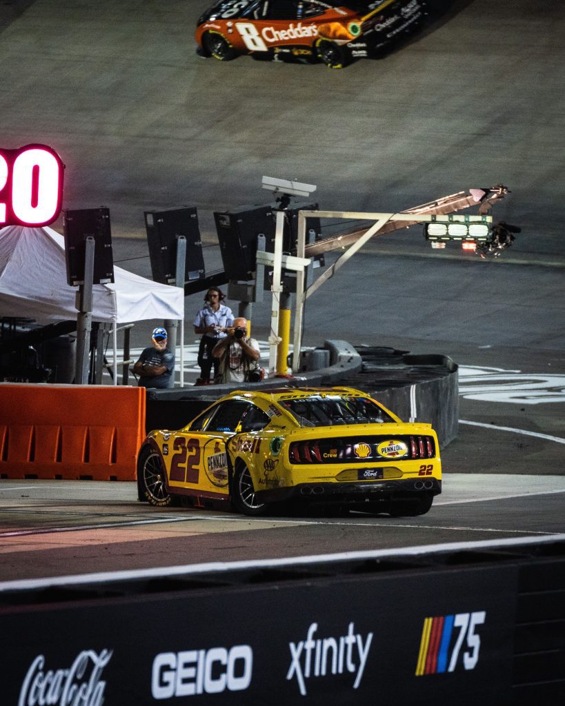 Joey Logano pulls his damaged car behind the wall at Bristol Motor Speedway