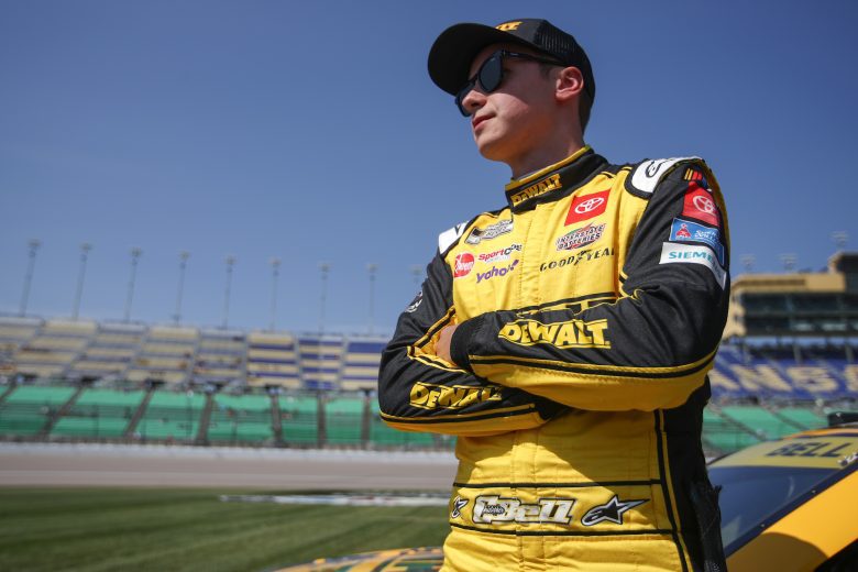 Christopher Bell stands on Kansas pit road with arms crossed
