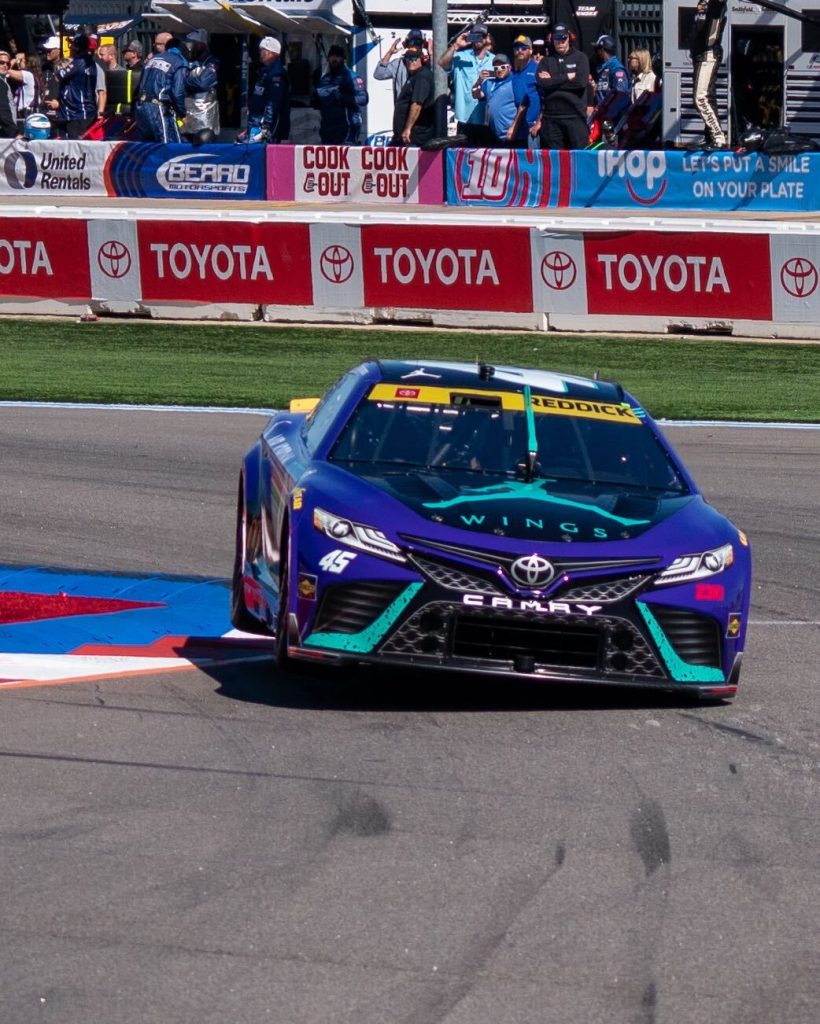 Tyler Reddick races at the Charlotte Motor Speedway Roval, jumping over a curb