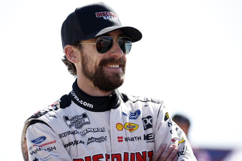 Ryan Blaney smiles and talks to crew member