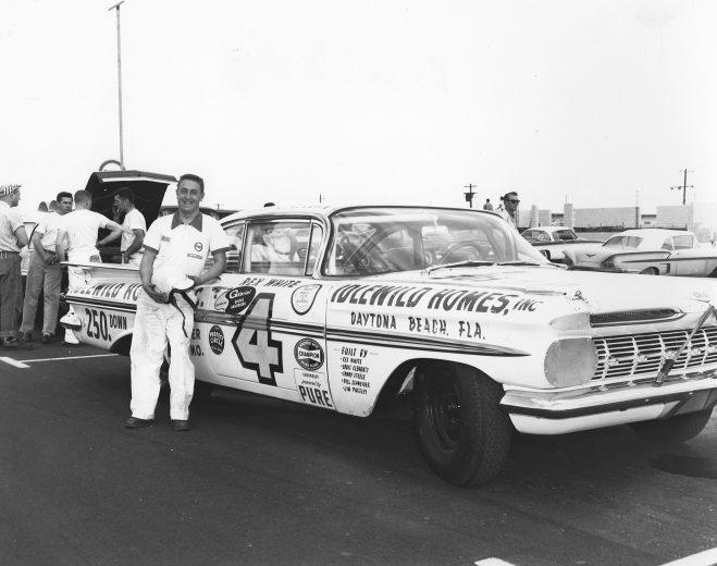 Rex White poses with his 1959 Chevrolet that he ran at the first Daytona 500 at Daytona International Speedway. White ended the race in 26th position after suffering an engine failure on lap 174.