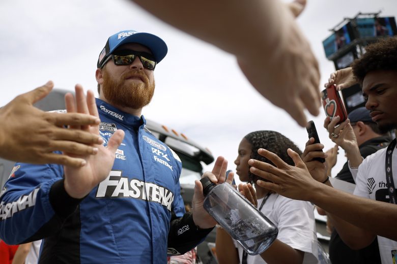 Chris Buescher gives high fives to fans as he walks by.