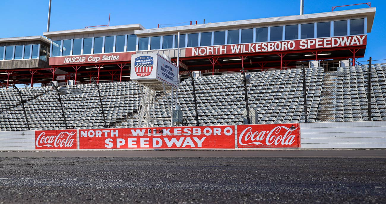 A general view of North Wilkesboro Speedway's grandstands with fresh pavement in the foreground.
