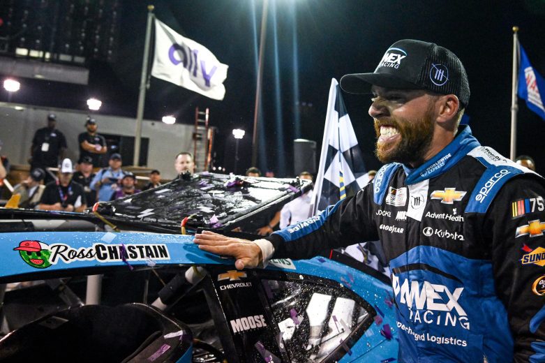 Ross Chastain places winner sticker on car.
