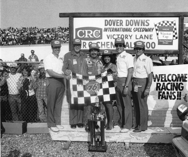 Neil Bonnett holds up checkered flag in Victory Lane.