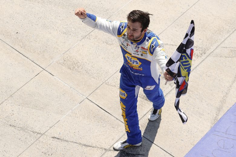 Chase Elliott celebrates holding checkered flag