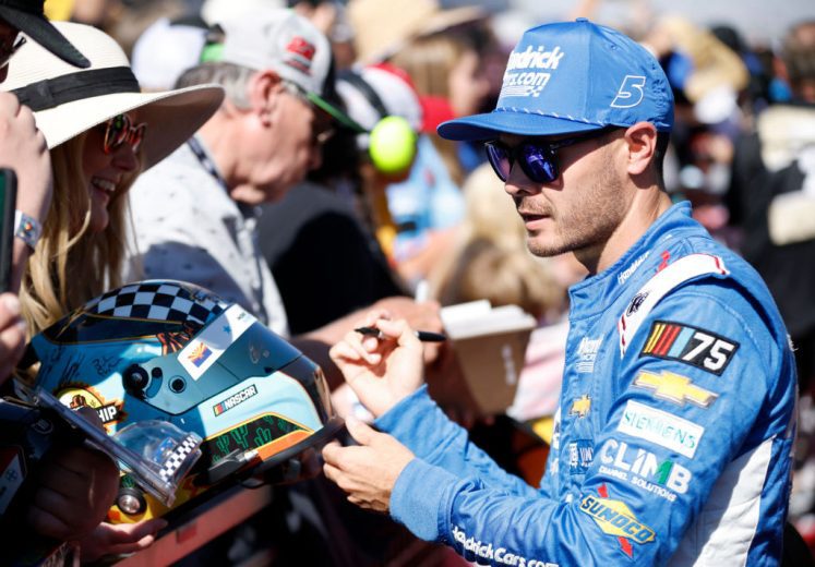 Kyle Larson signs autographs.
