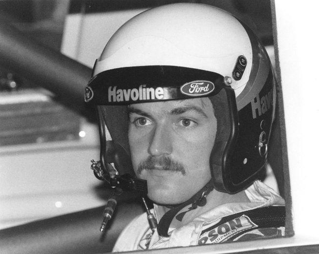 Davey Allison sits in race car.