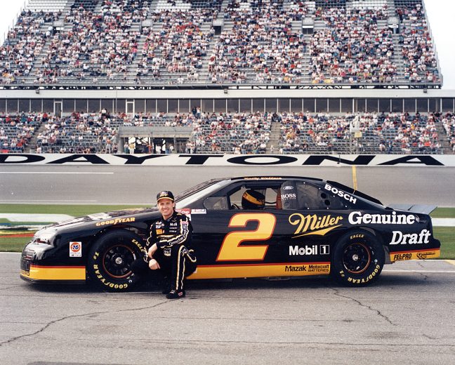 Rusty Wallace poses next to race car.