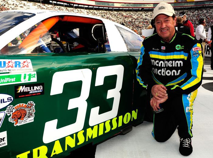 Harry Gant poses next to race car.
