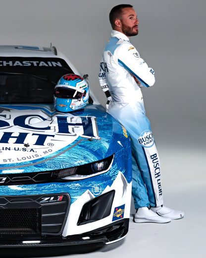 Ross Chastian leaning against the Number one Busch Light Chevrolet's front right side with race helmet placed on top of the hood