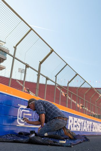 A crew worker paints the SAFER barrier at Los Angeles Memorial Coliseum.