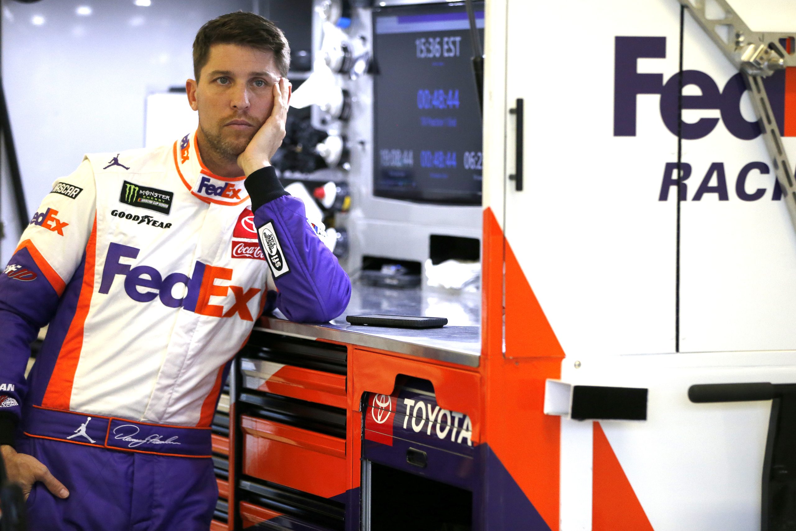 Denny Hamlin leans on a pit box in his garage with his head in his hand in this 2019 photo.