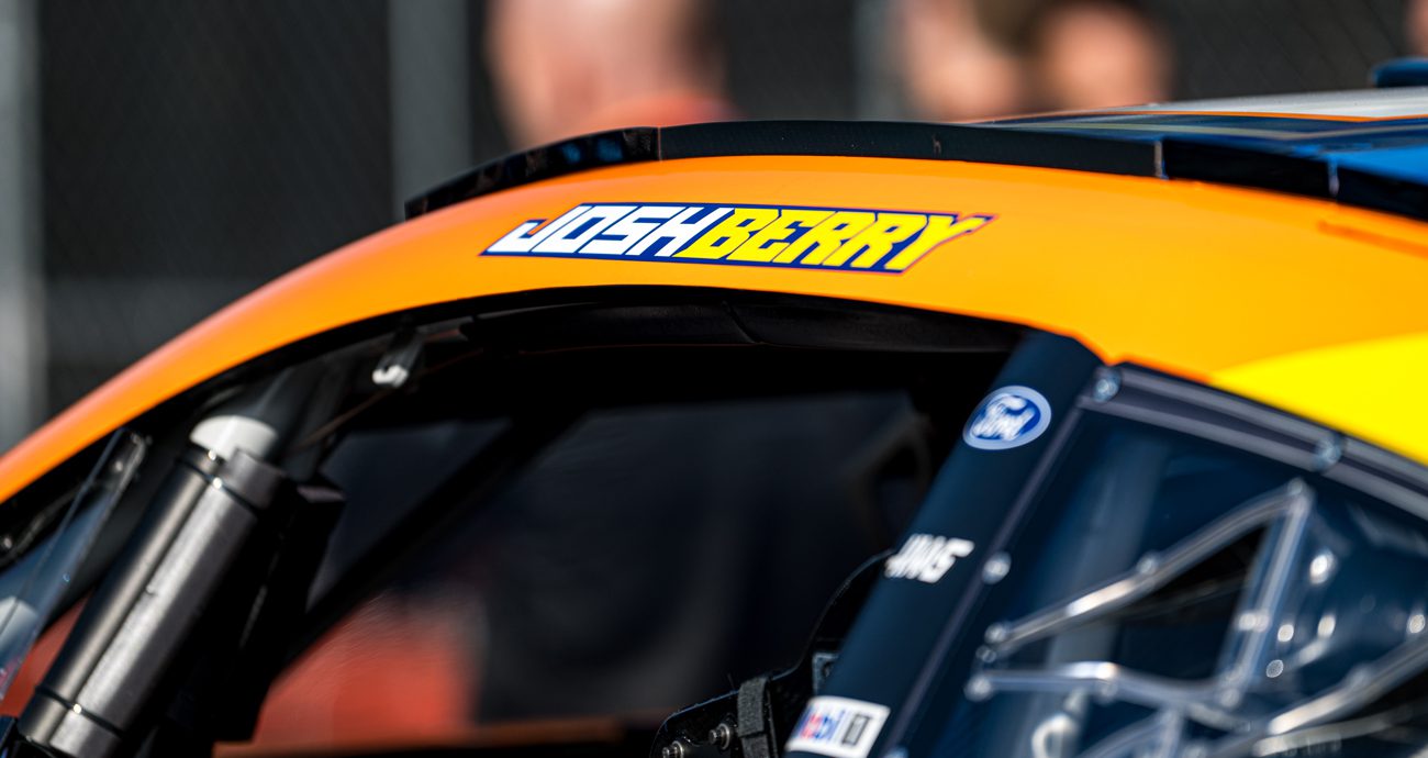 Josh Berry's name appears on the name rail above the driver-seat window of the No. 4 Stewart-Haas Racing Ford, with 'Josh' in a white font and 'Berry' in yellow on an orange background.