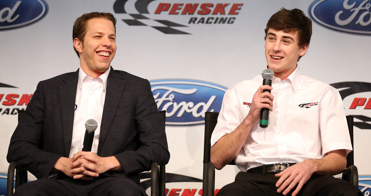 Brad Keselowski listens as Ryan Blaney talks to the media during the 2013