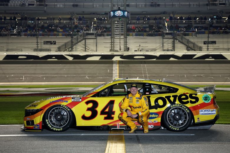 Michael McDowell poses next to his No. 34 Ford at Daytona International Speedway.