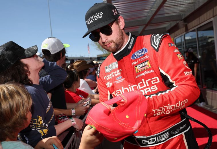 Chase Briscoe signs an autograph.