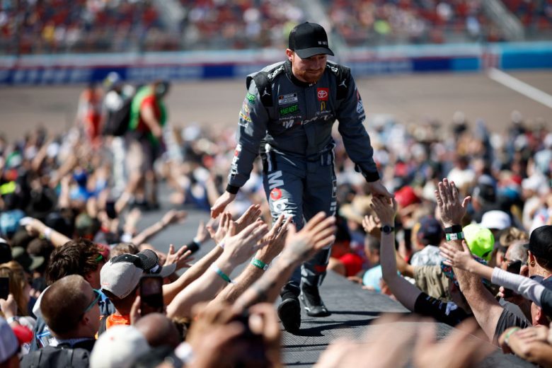 Tyler Reddick walks across the stage and greets fans.