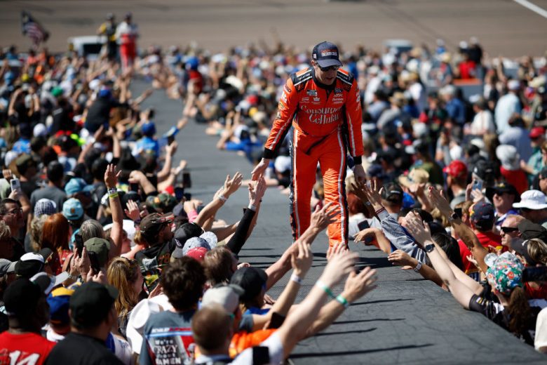 Brad Keselowski walks across the stage and greets fans.