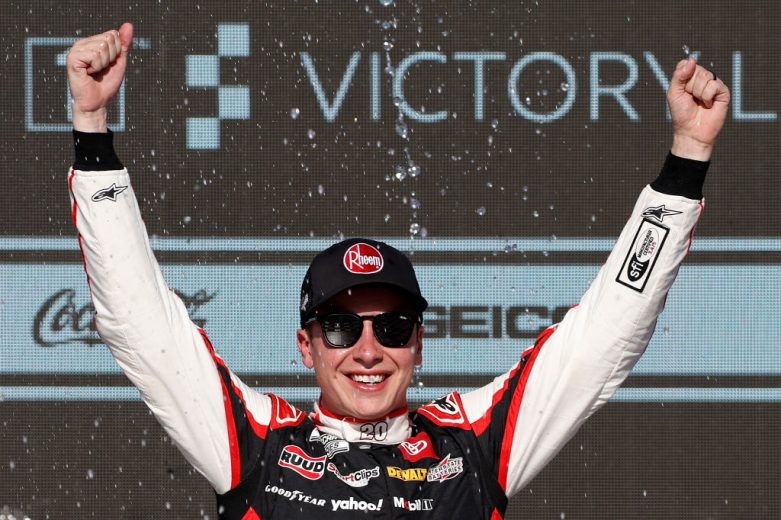 Christopher Bell raises his hands in celebration in Victory Lane at Phoenix Raceway.