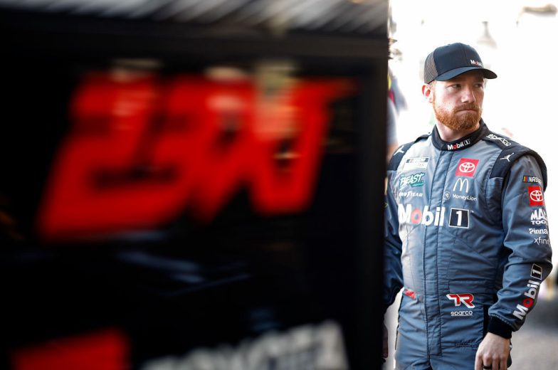 Tyler Reddick stands in the garage and looks on.