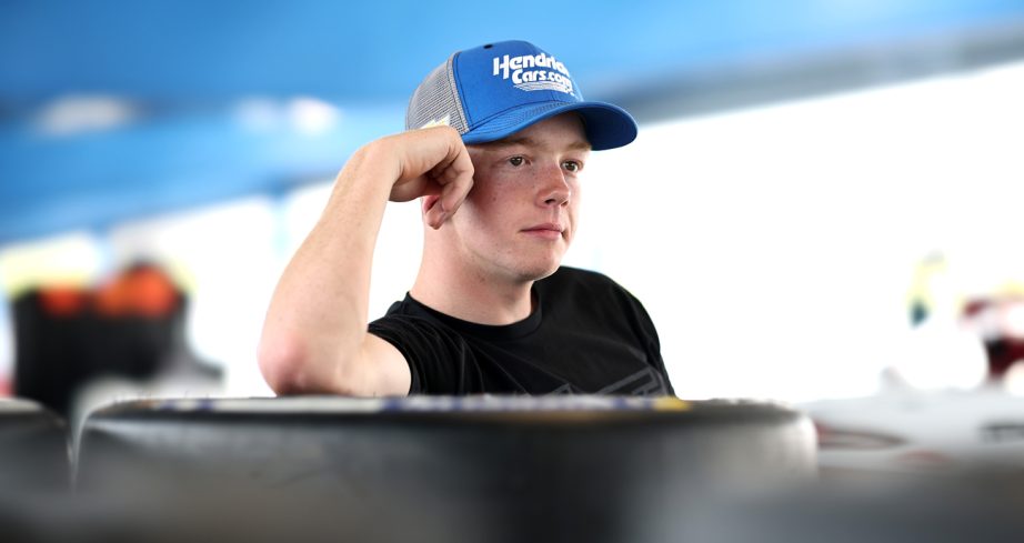 Connor Zilisch leans on tires during a test.