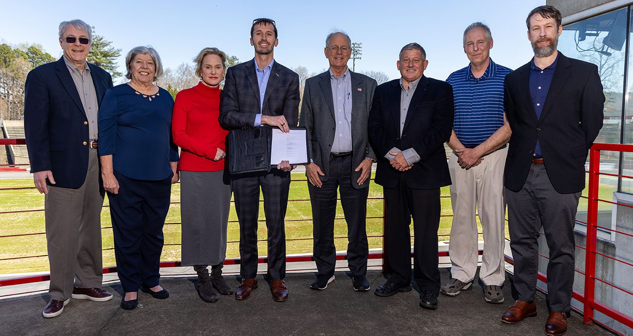 Key members pose following a historic signing at one of NASCAR