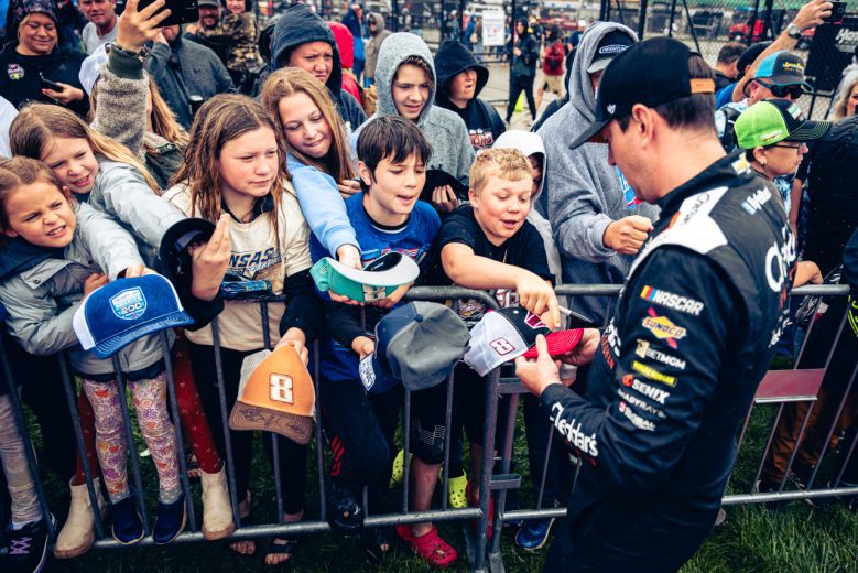 Kyle Busch signs autographs to fans at Kansas Speedway.