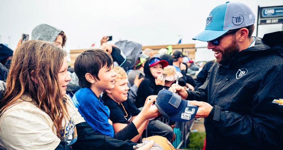 Ross Chastain signs autographs for fans at Kansas Speedway.
