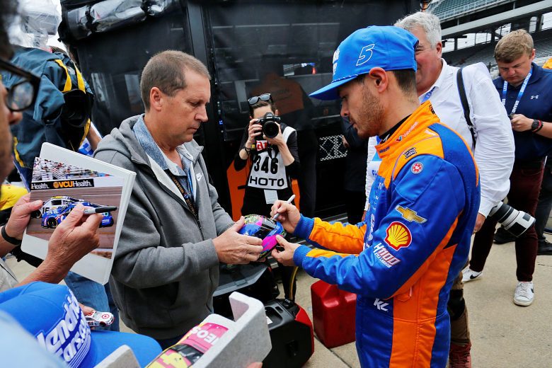 Kyle Larson signs autographs.